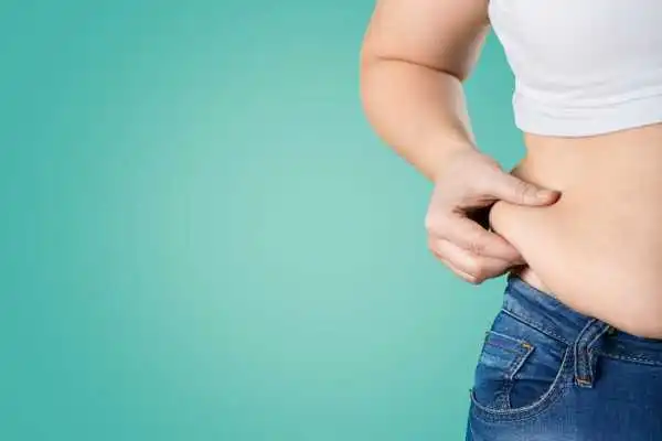 Image of woman pinching her love handles to show weight gain Soham